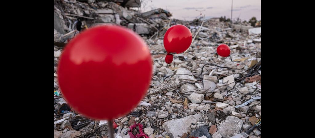 Balões pendurados nos escombros de um prédio desabado em Antakya, sul da Turquia