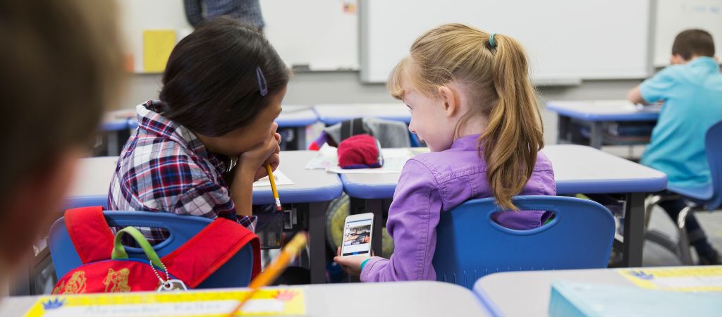 Estudantes acessando o celular na sala de aula